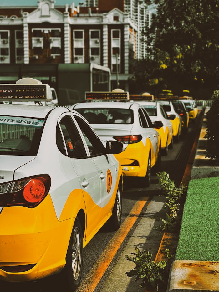 our-services-1 A row of yellow taxi cabs waits on a city street, providing urban transportation.