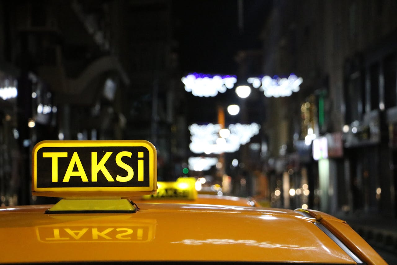 gallery-4 Urban night scene featuring a taxi with glowing lights on a bustling street.